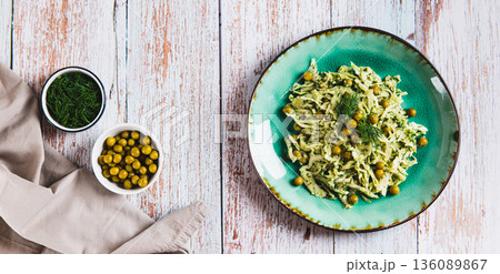 Vegetarian salad with cabbage, green peas and herbs on a plate on the table top view web banner 136089867
