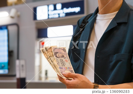 日本円を両替所前で持つ ■撮影協力:関西国際空港(KIX) 日本円を両替所前で持つ ■撮影協力:関西国際空港(KIX) 136090283