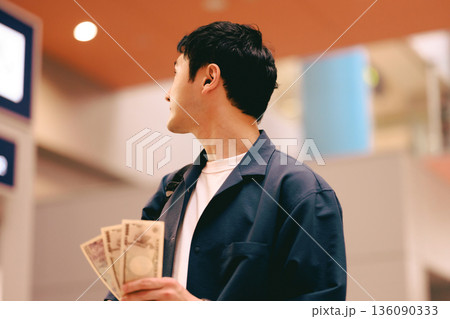券売機前で現金を構える男性 ■撮影協力:関西国際空港(KIX) 券売機前で現金を構える男性 ■撮影協力:関西国際空港(KIX) 136090333