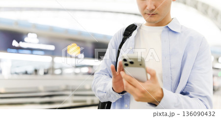 駅でスマホ操作する男性 ■撮影協力：関西国際空港（KIX） 136090432