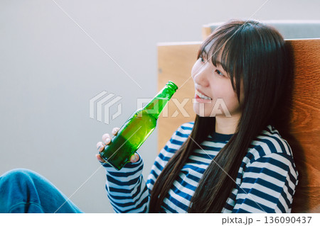 リビングでビールを飲む若い女性 リビングでビールを飲む若い女性 136090437