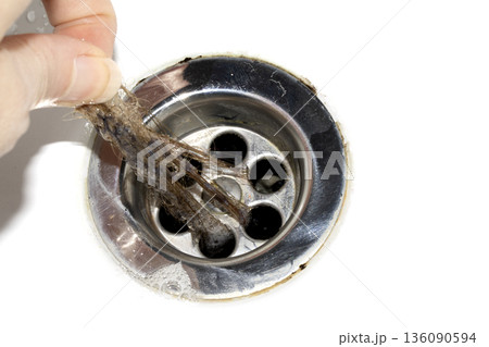 Unblocking brown hair from sink hole drain close up unhygenic gross job 136090594