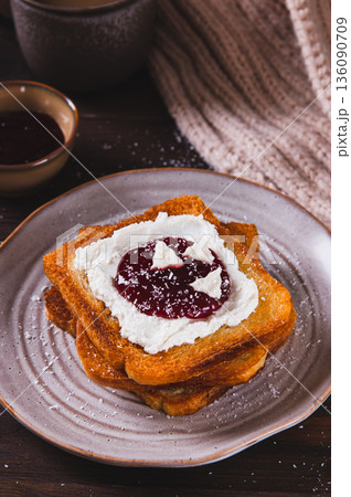 Delicious toasts with cream cheese, jam, paste and coconut flakes on a plate vertical view Delicious toasts with cream cheese, jam, paste and coconut flakes on a plate vertical view 136090709