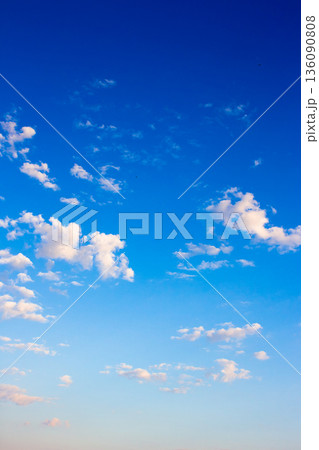 vertical blue sky with white soft clouds. clear atmosphere for summer weather background. peaceful nature on a sunny morning. scenic outdoor pattern for meteorology or idyllic holiday aesthetic 136090808