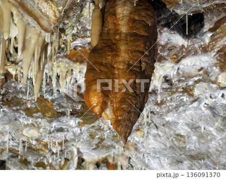 water drop falling from stalactite inside karst caves carved out by water 136091370