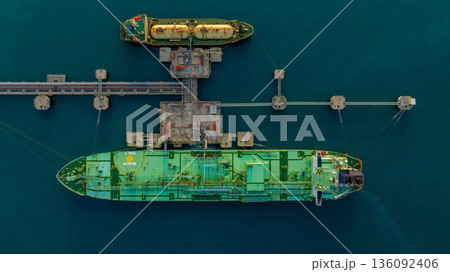 Aerial view LPG tanker ship at oil and gas terminal platform, Liquefied Petroleum Gas tanker ship industrial oil gas terminal tanker ship, LPG tanker ship loading and unloading petrochemical industry. Aerial view LPG tanker ship at oil and gas terminal platform, Liquefied Petroleum Gas tanker ship industrial oil gas terminal tanker ship, LPG tanker ship loading and unloading petrochemical industry. 136092406