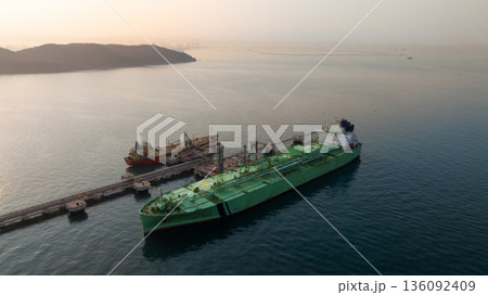 Aerial view LPG tanker ship at oil and gas terminal platform, Liquefied Petroleum Gas tanker ship industrial oil gas terminal tanker ship, LPG tanker ship loading and unloading petrochemical industry. Aerial view LPG tanker ship at oil and gas terminal platform, Liquefied Petroleum Gas tanker ship industrial oil gas terminal tanker ship, LPG tanker ship loading and unloading petrochemical industry. 136092409