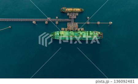 Aerial view LPG tanker ship at oil and gas terminal platform, Liquefied Petroleum Gas tanker ship industrial oil gas terminal tanker ship, LPG tanker ship loading and unloading petrochemical industry. Aerial view LPG tanker ship at oil and gas terminal platform, Liquefied Petroleum Gas tanker ship industrial oil gas terminal tanker ship, LPG tanker ship loading and unloading petrochemical industry. 136092481