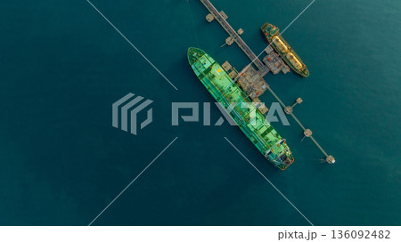 Aerial view LPG tanker ship at oil and gas terminal platform, Liquefied Petroleum Gas tanker ship industrial oil gas terminal tanker ship, LPG tanker ship loading and unloading petrochemical industry. Aerial view LPG tanker ship at oil and gas terminal platform, Liquefied Petroleum Gas tanker ship industrial oil gas terminal tanker ship, LPG tanker ship loading and unloading petrochemical industry. 136092482