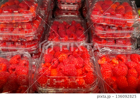 Fresh Red Raspberries in Clear Plastic Containers at Market 136092825