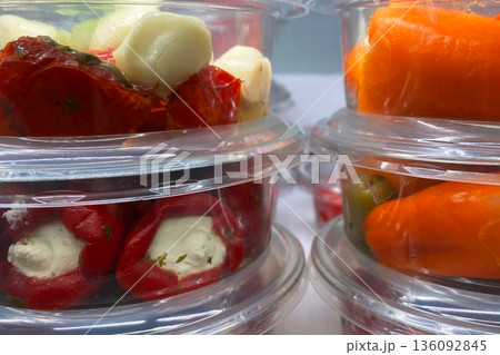Assorted Stuffed Peppers and Marinated Delicacies in Plastic Containers 136092845