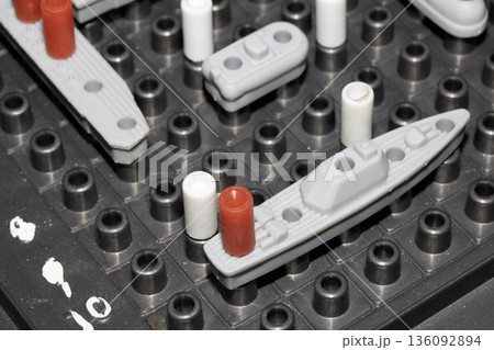 Close up of strategic battleships board game with ships and pegs Close up of strategic battleships board game with ships and pegs 136092894