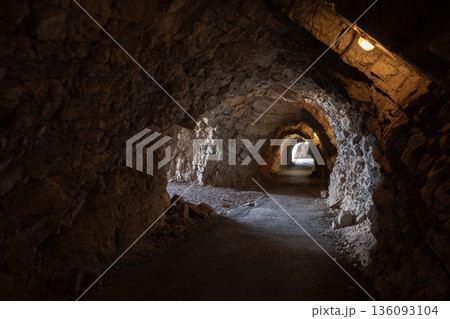 A rugged underground tunnel carved from stone 136093104
