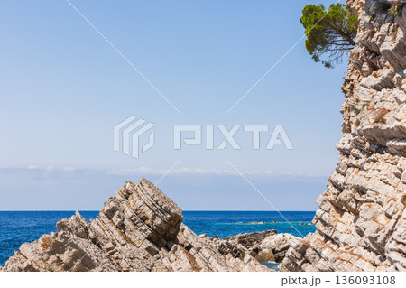 Jagged coastal rocks meet the deep blue sea Jagged coastal rocks meet the deep blue sea 136093108