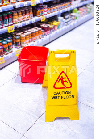 Caution Wet Floor yellow warning sign in a superstore Caution Wet Floor yellow warning sign in a superstore 136093824