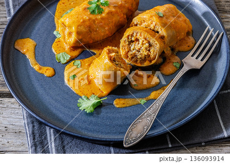 Stuffed cabbage rolls with quinoa and tomato sauce 136093914