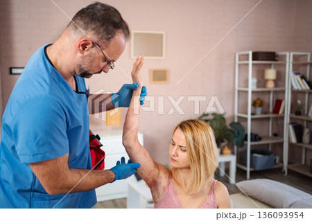 Doctor examining woman's skin rash during home visit Doctor examining woman's skin rash during home visit 136093954