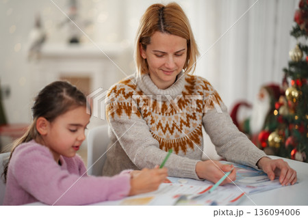 Mother daughter coloring Christmas holiday together at home 136094006