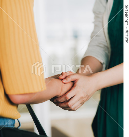 手を取り合う二人の女性 ■撮影協力：関西国際空港（KIX） 136094140