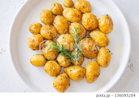 Oven baked baby potatoes seasoned with herbs served in white ceramic bowl Oven baked baby potatoes seasoned with herbs served in white ceramic bowl 136095284