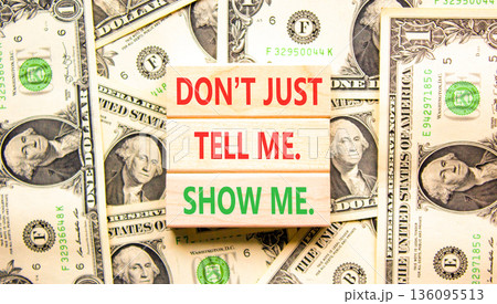 Tell or show symbol. Concept words Do not just tell me, show me on beautiful wooden blocks. Beautiful dollar bills background. Dollar bills. Business tell or show concept. Copy space. 136095513