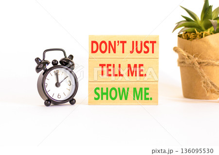 Tell or show symbol. Concept words Do not just tell me, show me on beautiful wooden blocks. Beautiful white background. Black alarm clock. Business tell or show concept. Copy space. 136095530