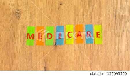 Medicare word symbol. Concept word Medicare on beautiful colored papers. Beautiful wooden background. Medical support help medicare word concept. Copy space. 136095590