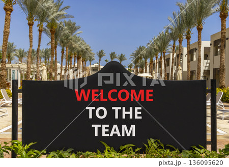 Support, help welcome to the team symbol. Concept words Welcome to the team on beautiful black road sign. Beautiful palm trees blue sky background. Business welcome to the team concept. Copy space. Support, help welcome to the team symbol. Concept words Welcome to the team on beautiful black road sign. Beautiful palm trees blue sky background. Business welcome to the team concept. Copy space. 136095620
