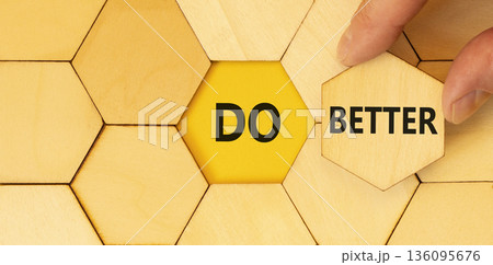Do better symbol. Concept words Do better on beautiful wooden puzzle. Beautiful wooden background. Businessman hand. Business and do better concept. Copy space. Do better symbol. Concept words Do better on beautiful wooden puzzle. Beautiful wooden background. Businessman hand. Business and do better concept. Copy space. 136095676