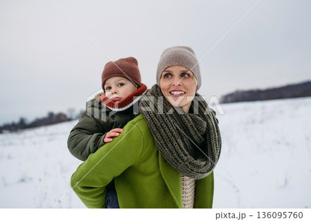 Mother on walk in winter nature with little son. Mother on walk in winter nature with little son. 136095760