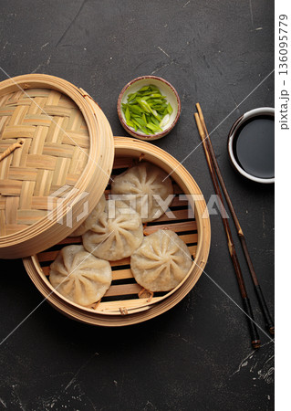Chinese food dim sum bao dumplings bamboo steamer chopsticks black background Chinese food dim sum bao dumplings bamboo steamer chopsticks black background 136095779