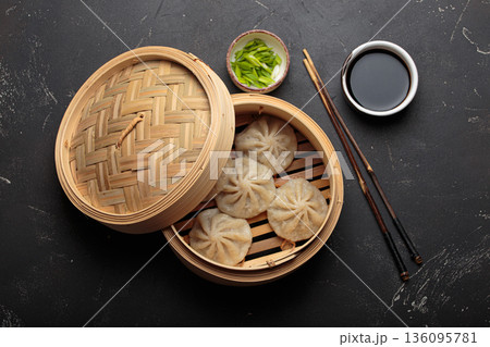 Chinese food dim sum bao dumplings bamboo steamer chopsticks black background Chinese food dim sum bao dumplings bamboo steamer chopsticks black background 136095781