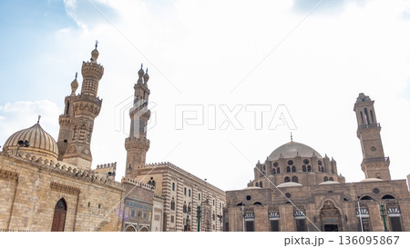 Al-Azhar Mosque in Cairo features intricate architecture with tall minarets and a domed roof. The structure showcases Islamic design elements and historical significance. Al-Azhar Mosque in Cairo features intricate architecture with tall minarets and a domed roof. The structure showcases Islamic design elements and historical significance. 136095867