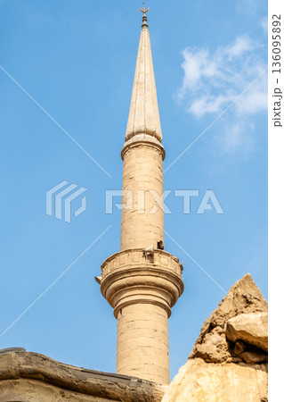 Sulayman Agha Al-Silahdar Mosque in Cairo, featuring a tall minaret and intricate architectural details against a clear blue sky. 136095892