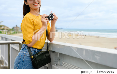 幻想的な海辺でカメラを持つ女性 136095943