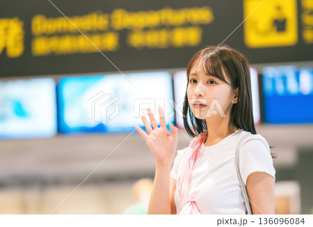 空港で手を振る女性 ■撮影協力：関西国際空港（KIX） 136096084