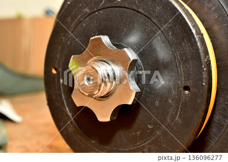 Fastening a collapsible dumbbell with a nut. 136096277