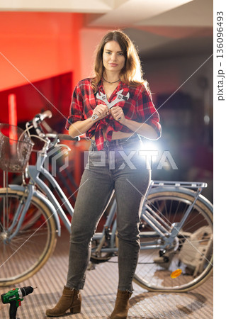Young woman enjoying bicycle repair and maintenance work 136096493