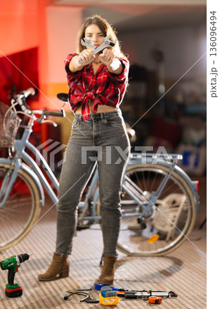 Young woman holding wrenches ready for bicycle repair Young woman holding wrenches ready for bicycle repair 136096494