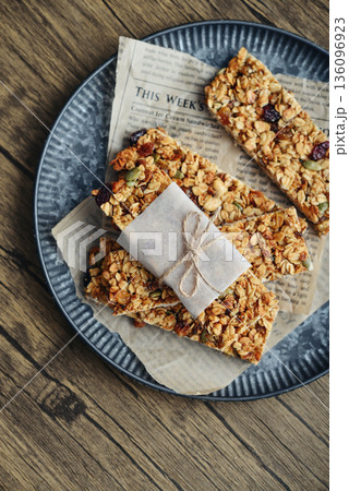 Gluten-free oat granola bars with nuts and berries on round vintage metal tray Gluten-free oat granola bars with nuts and berries on round vintage metal tray 136096923
