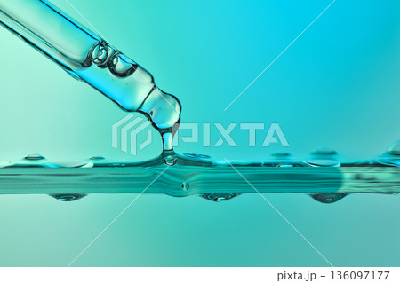 Liquid dropper releasing fluid onto a calm surface 136097177