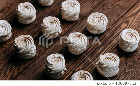 Vanilla meringue swirls on rustic wooden table, diagonal pattern, copy space Vanilla meringue swirls on rustic wooden table, diagonal pattern, copy space 136097512