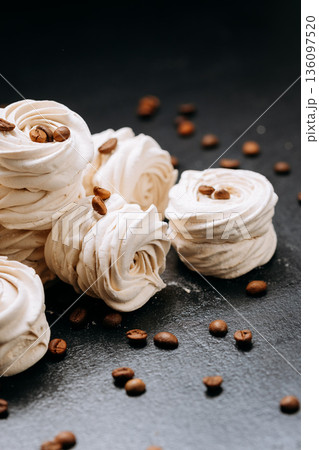 Coffee bean topped meringue cookies on dark slate with copy space Coffee bean topped meringue cookies on dark slate with copy space 136097520
