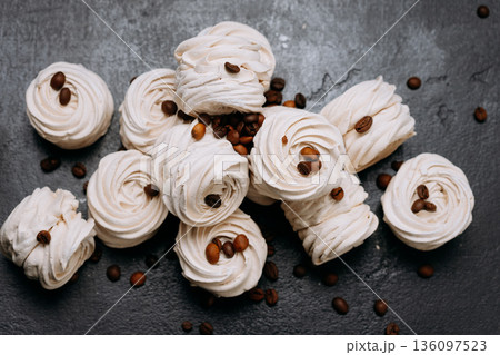 Sweet meringue dessert and roasted coffee beans, dark background flat lay Sweet meringue dessert and roasted coffee beans, dark background flat lay 136097523