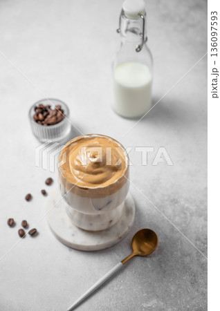 Iced Dalgona coffee on a gray concrete background with coffee beans and spoon. Iced Dalgona coffee on a gray concrete background with coffee beans and spoon. 136097593