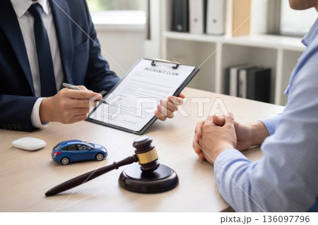 Insurance Agent Consulting Client About Car Accident Claim with Gavel on Desk Insurance Agent Consulting Client About Car Accident Claim with Gavel on Desk 136097796