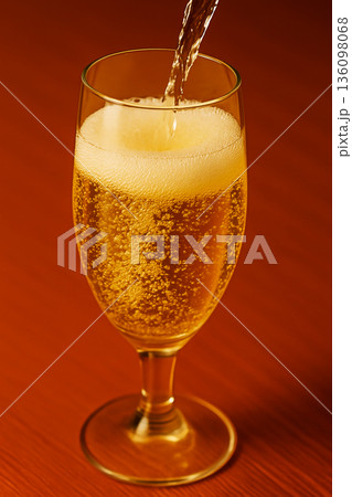 グラスに注がれる黄金色のビールと泡のクローズアップ 136098068
