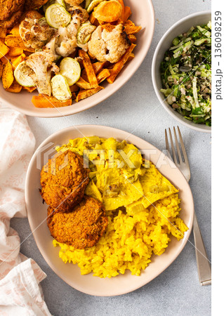 A colorful spread featuring rice with rhubarb fried eggs, baked sweet potato, and sauteed cauliflower and zucchini A colorful spread featuring rice with rhubarb fried eggs, baked sweet potato, and sauteed cauliflower and zucchini 136098259