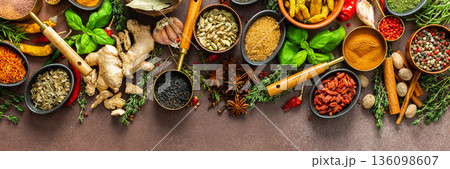 An elegant arrangement of spices and herbs in vivid colors, set against a brown surface, highlighting their aromatic richness and visual diversity, banner An elegant arrangement of spices and herbs in vivid colors, set against a brown surface, highlighting their aromatic richness and visual diversity, banner 136098607