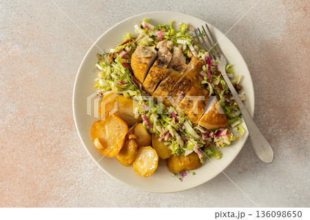 Fresh baked potatoes and chicken breast served with a salad of Chinese cabbage and pink radish make a healthy breakfast option. This meal is prepared at home and offers nutrition Fresh baked potatoes and chicken breast served with a salad of Chinese cabbage and pink radish make a healthy breakfast option. This meal is prepared at home and offers nutrition 136098650